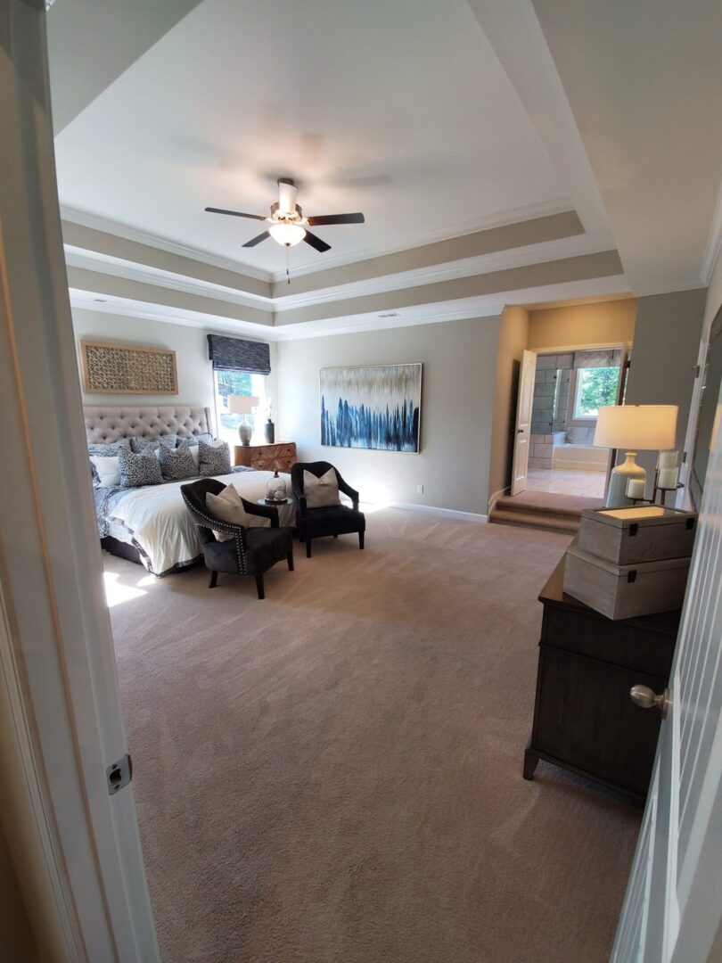 Carpeted bedroom with a king bed and two chairs.