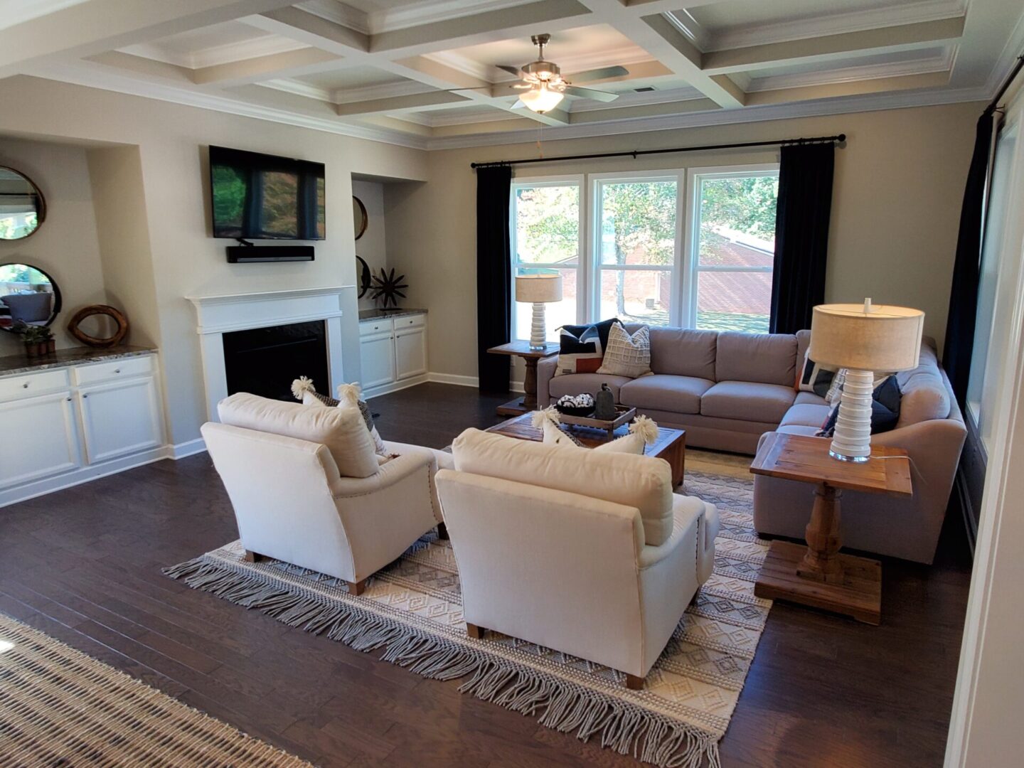 Living room with sectional sofa and white chairs.