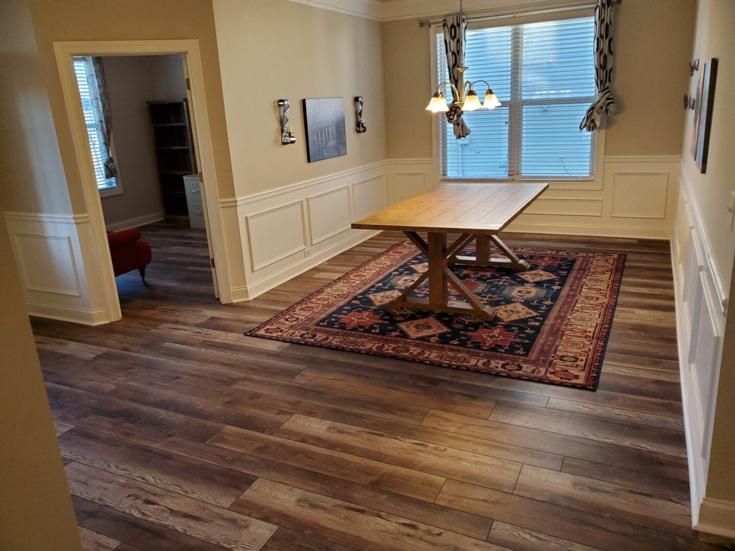 Dining room with wooden table and rug.