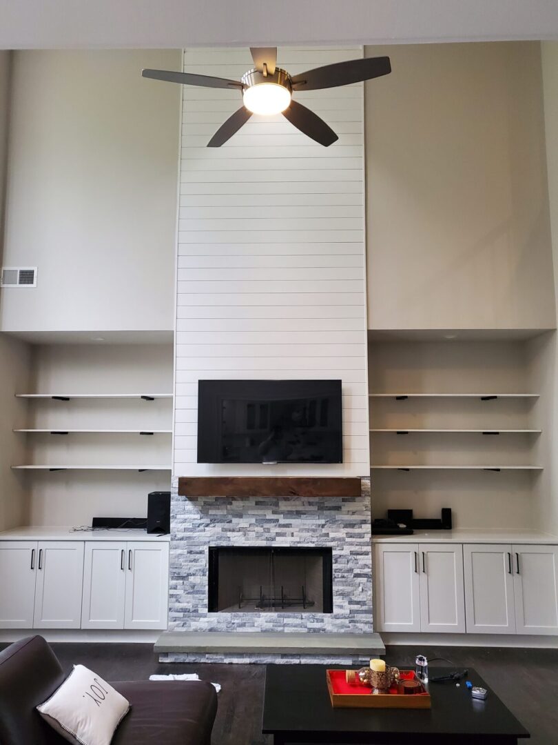 White fireplace with a TV above it.
