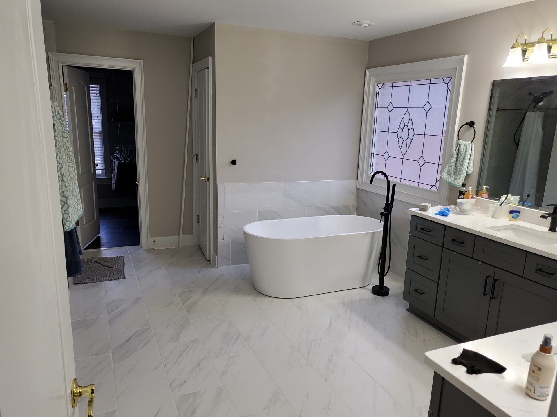 Modern bathroom with white bathtub and tile floor.