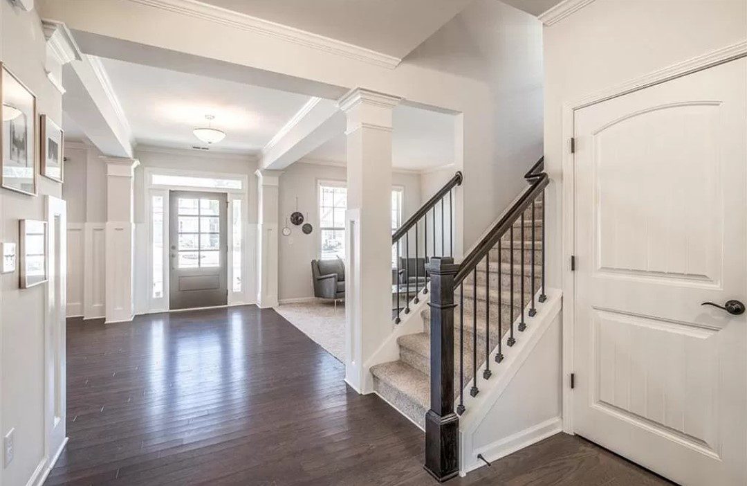 White entryway with staircase and door.