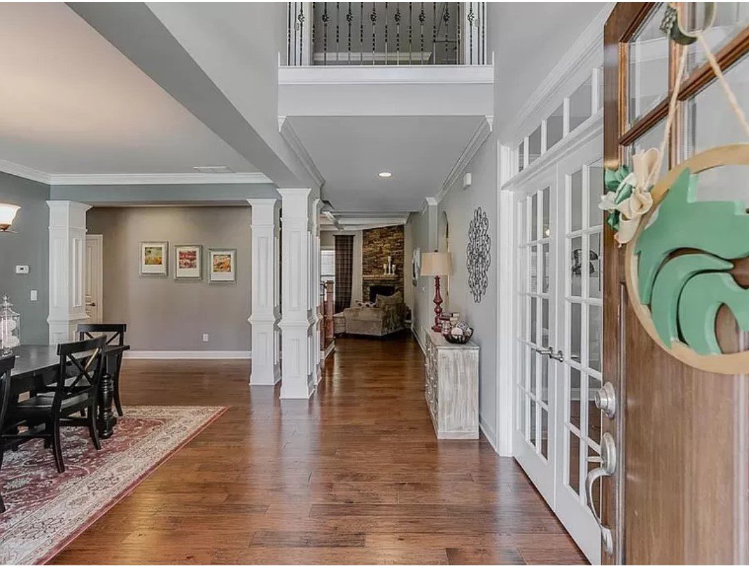 Spacious entryway with hardwood floors and French doors.